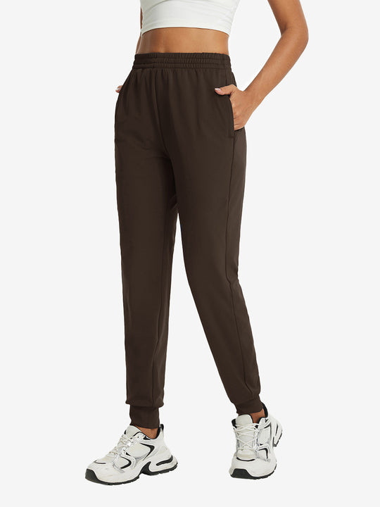 Model with hand in pocket wearing lightweight women's stretchy joggers sweatpants in coffee brown.