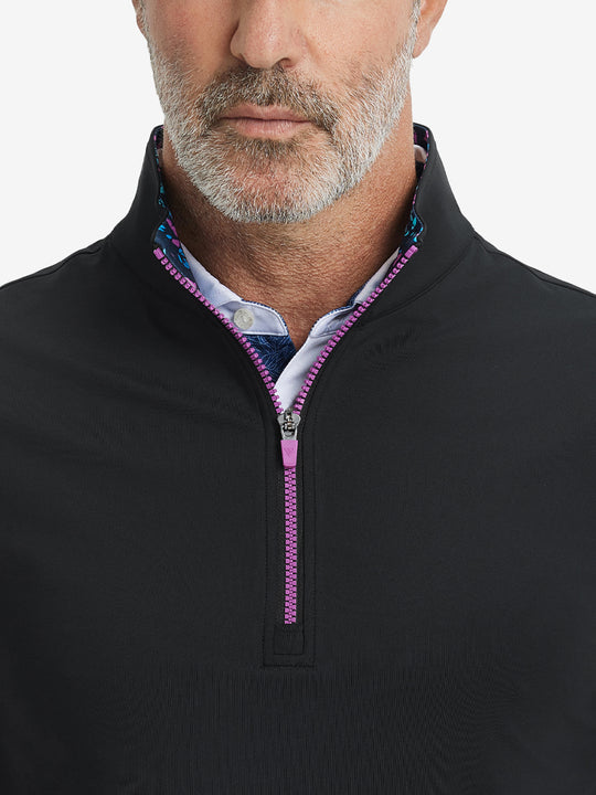 Close-up from nose to chest, showing collar detail and zipper of the black golf vest.