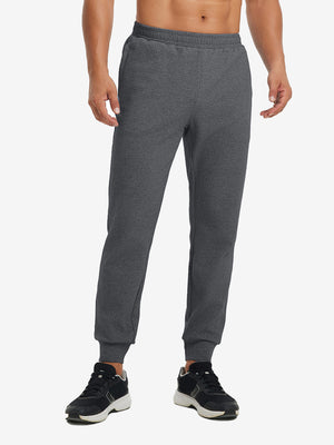 Front lower body view of model wearing soft sweatpants with 4 zipper pockets in grey heather