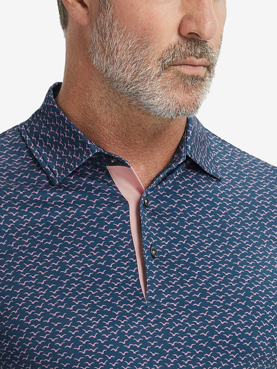 Close-up from nose to chest, showing collar and fabric pattern detail of the navy pink seagull polo shirt.
