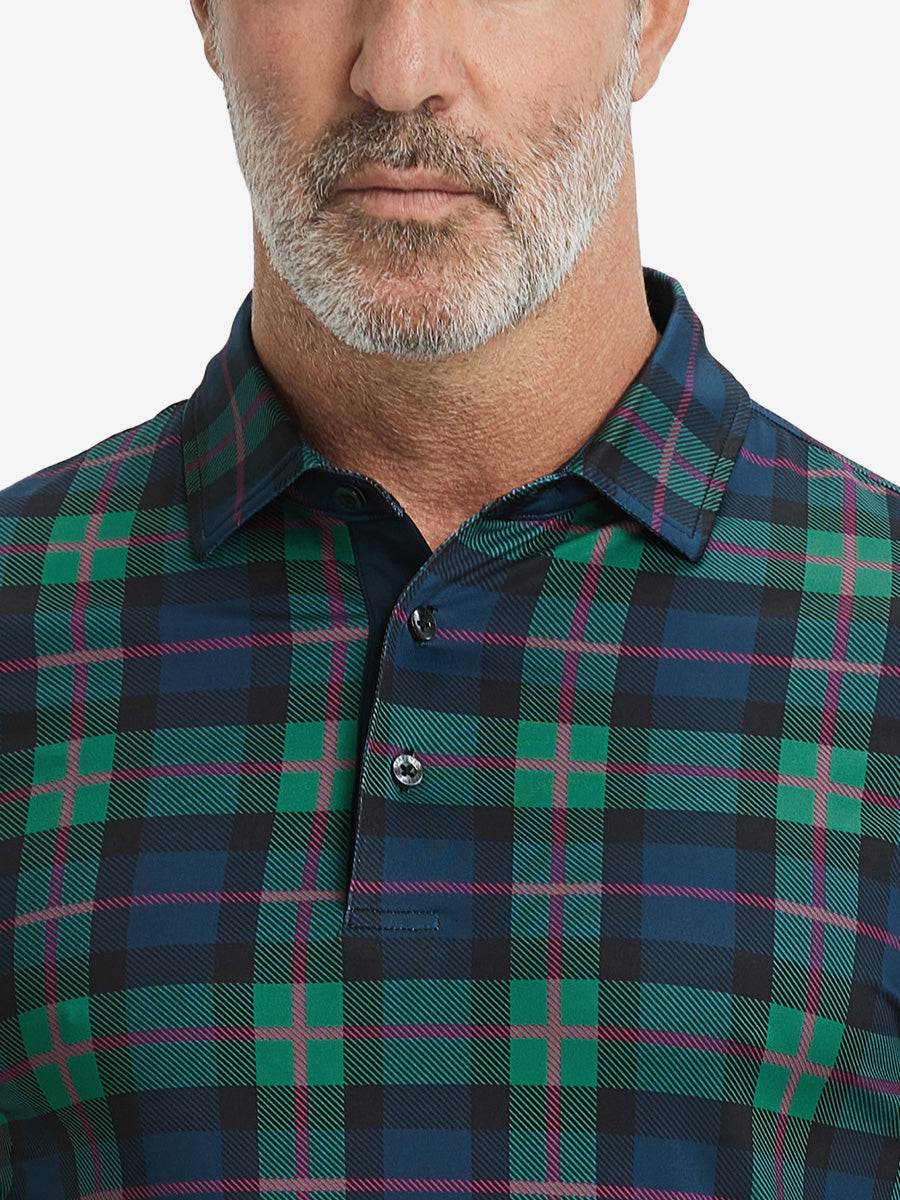 Close-up from nose to chest, showing collar and fabric pattern detail of the dark plaid polo shirt.
