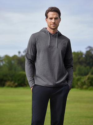 Model in neutral grey heather classic heather fleece hoodies on the golf course, half-body shot