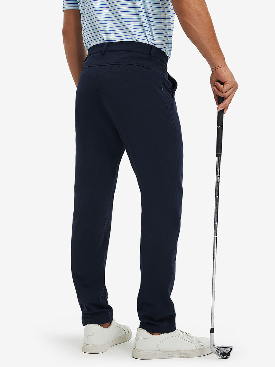 3D back view of lightweight moisture wicking dress pants on model holding golf club in navy.