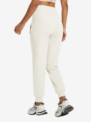 Model wearing women's stretch fleece lined water resistant joggers in beige, showing the back lower body view.