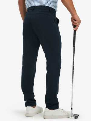 Back lower-body view of lightweight moisture wicking dress pants, model with golf club in navy.