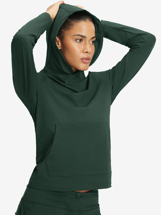 Model holding hoodie cap with both hands, wearing women's lightweight hoodies pullover in forest green.
