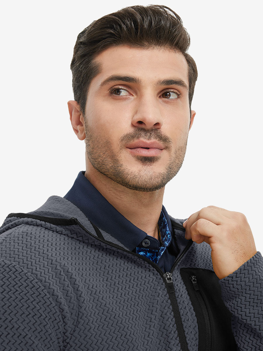 Model holding collar with one hand, wearing full zip fleece hoodied jacket in grey.