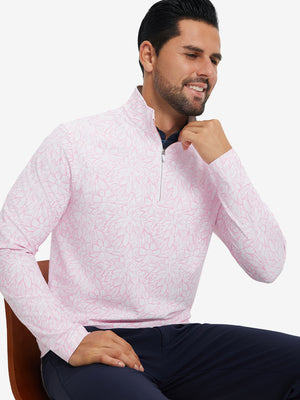Model seated on chair, wearing full print quarter zip pullover in pink artichoke, casual upper body view.