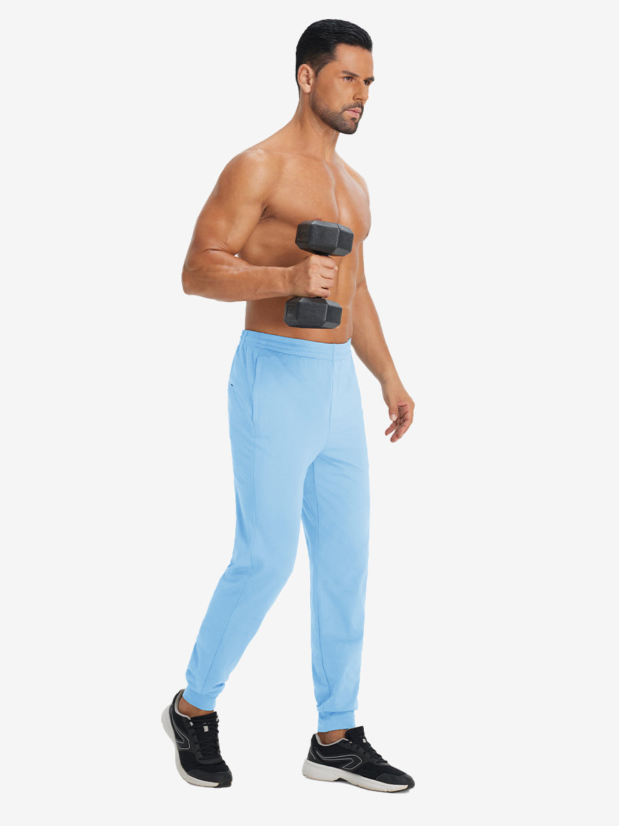 Model holding tennis racket wearing lightweight traning track pants in light blue.
