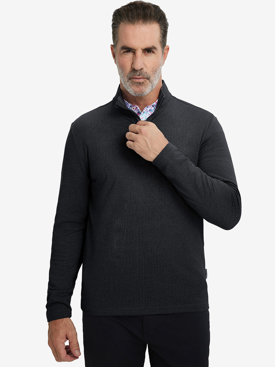Model grabbing half-zip collar, wearing casual fleece lined quarter zip pullover in black.