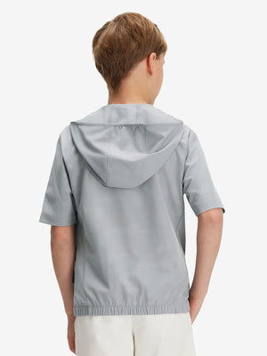 Back waist-up shot of model wearing light grey water-resistant short sleeve q-zip hoodie for boys