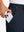 Hand placing an iPhone into pocket of lightweight flat front casual trousers in navy.