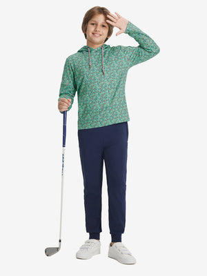 A full-body shot of a model wearing a youth full print stylish hoodie pullover in bluejay green rugby.