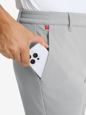 Close-up detail showing phone being placed in the pocket of light grey water-resistant stretch heat-tech winter trousers