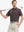 Model in BROWN STRIPE Golf Polo holding club — dynamic front half-body pose