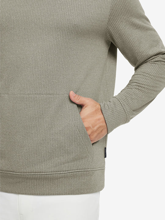 Close-up of model with both hands in pockets wearing warm fleece golf hoodies pullover  dust beige.