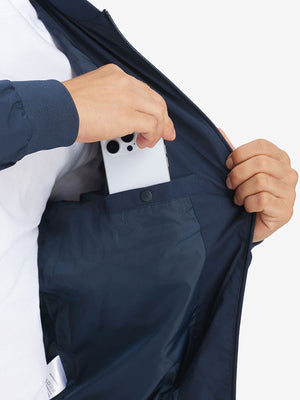 Hand placing iPhone into inner pocket of casual windproof bomber jacket in navy