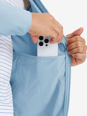 Hand placing iPhone into inner pocket of lightweight water-resistant outerwear jacket in light blue