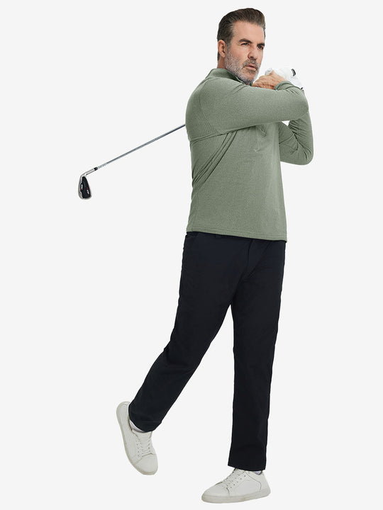 Model finishing golf swing, holding club, wearing casual fleece lined quarter zip pullover in green.