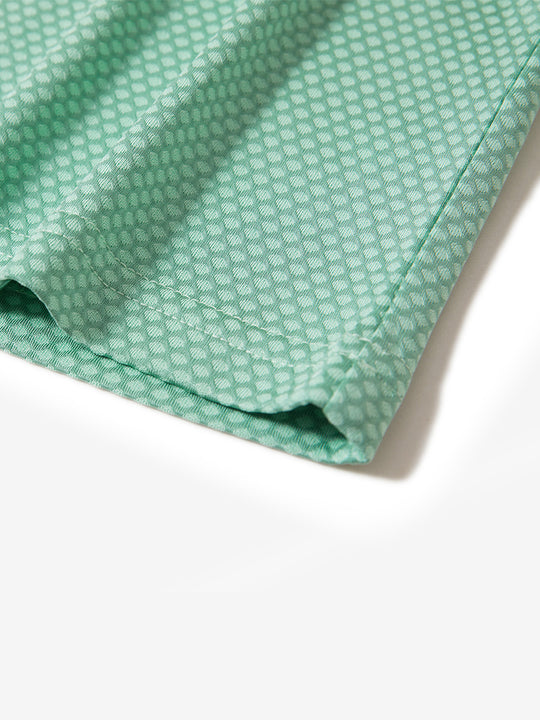 Hem detail of jacquard quarter zip pullover in light green, focusing on stitching and side vent finish.