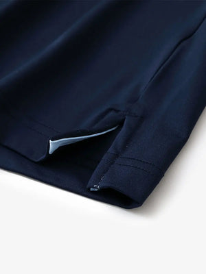 Hem slit detail of NAVY Moisture Wicking Color Block Polo Shirt highlighting stitching and finish.