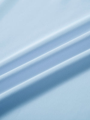 Close-up of sky blue ventilated pique performance polo fabric showing breathable texture.