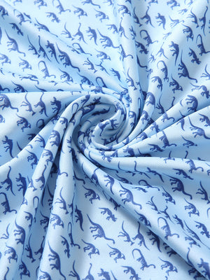 Close-up of blue dinosaur performance jersey print polo fabric showing breathable texture and vibrant pattern details.
