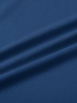 Close-up of blue ventilated pique performance polo fabric texture.