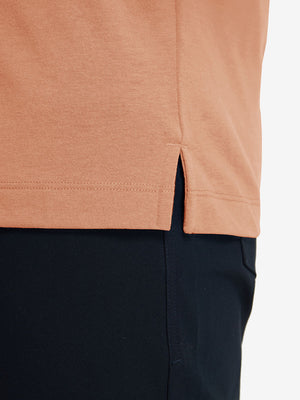 Detail shot of the hem on the orange adobe heather comfy cotton blend polo shirt with pocket, emphasizing the bottom edge design