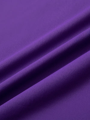 Close-up of purple ventilated pique performance polo fabric showing breathable texture.