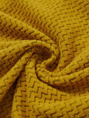 Fabric close-up of warm stretchy quarter zip with pocket, smooth knit texture and flexible feel in yellow