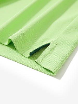 Close-up of the hem vent on the turquoise green ventilated pique performance polo, showing the side split for movement