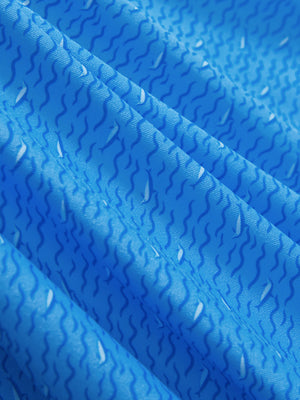 Close-up of blue wave dolphin golf polo shirts, showcasing texture and print details.