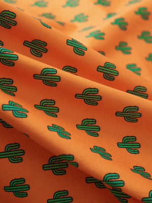 Close-up of orange cactus performance print boys golf polo, showcasing texture and print details.