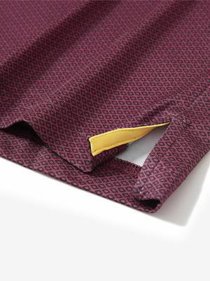 Close-up of the hem vent on the burgundy geometric 4 way stretch print collared polo shirt, showing the side split for movement