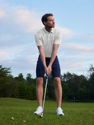 Model in light grey your favorite jacquard polo preparing to tee off, full-body shot