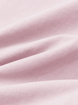 Macro view of the pink youth water resistant cotton blend golf pants fabric, showcasing the water repellent surface
