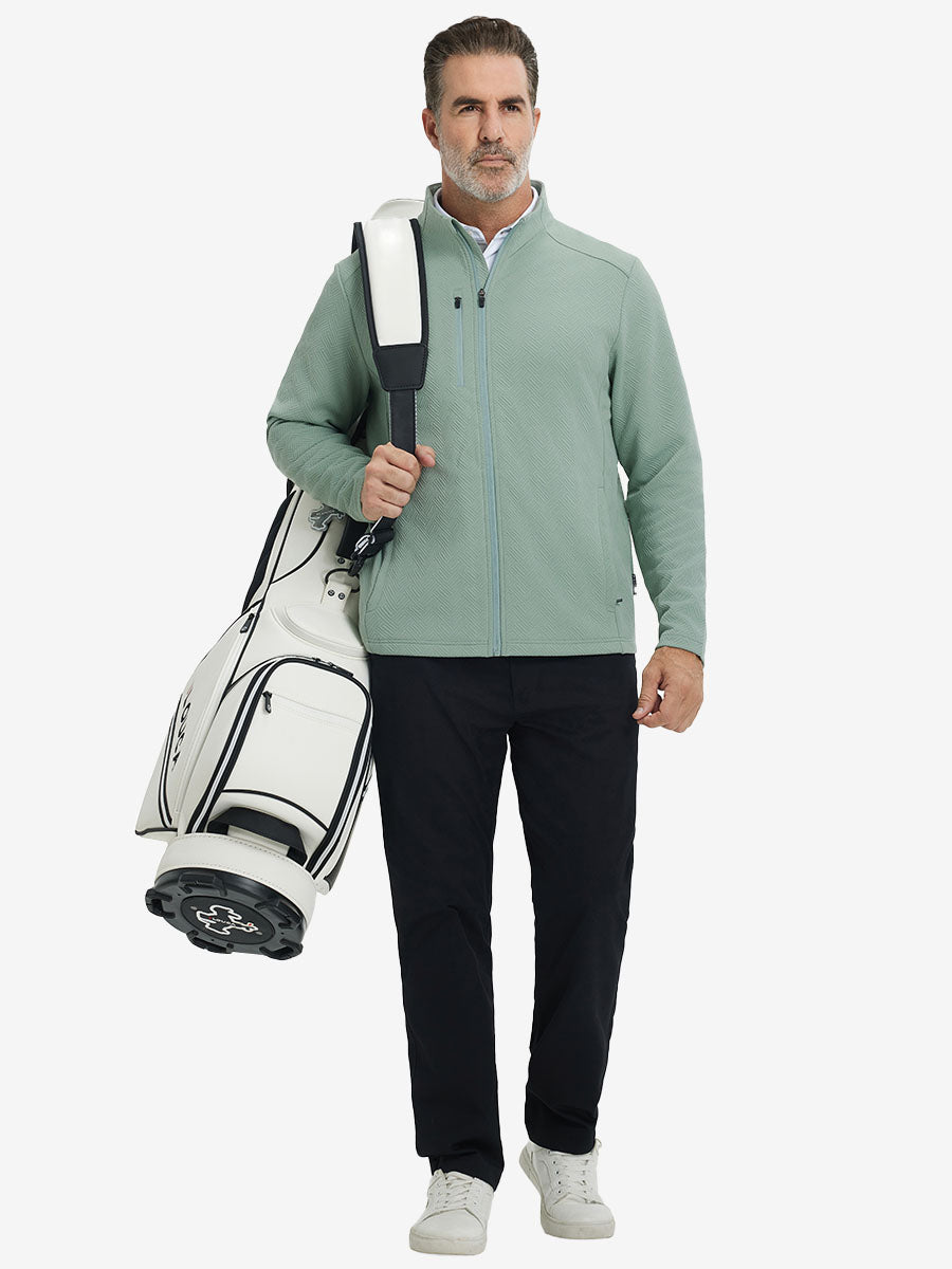 Full body shot, model carrying golf bag in textured insulated winter jacket, active outdoor style, beryl green.
