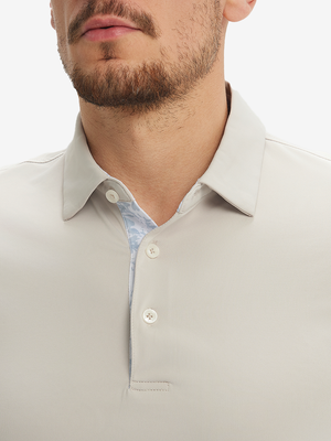 Close-up of a model wearing the oyster gray everyday classic solid polo, focusing on the collar and chest area