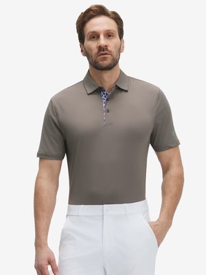 Front half-body view of a model wearing the light brown everyday classic solid polo, displaying the chest pocket detail