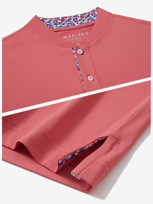 Detail of brick red moisture-wicking short sleeve henley shirt showing collar and hem vent construction.