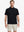 Half-body front view holding a golf club, wearing the BLACK polo on the course.